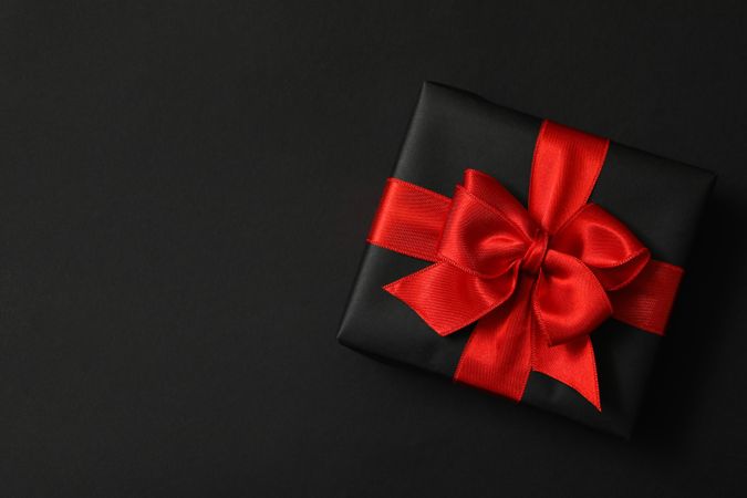 Gift box with red bow on dark background