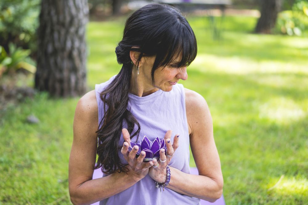 woman holding holding a purple glass lotus. Yoga and meditation concept.