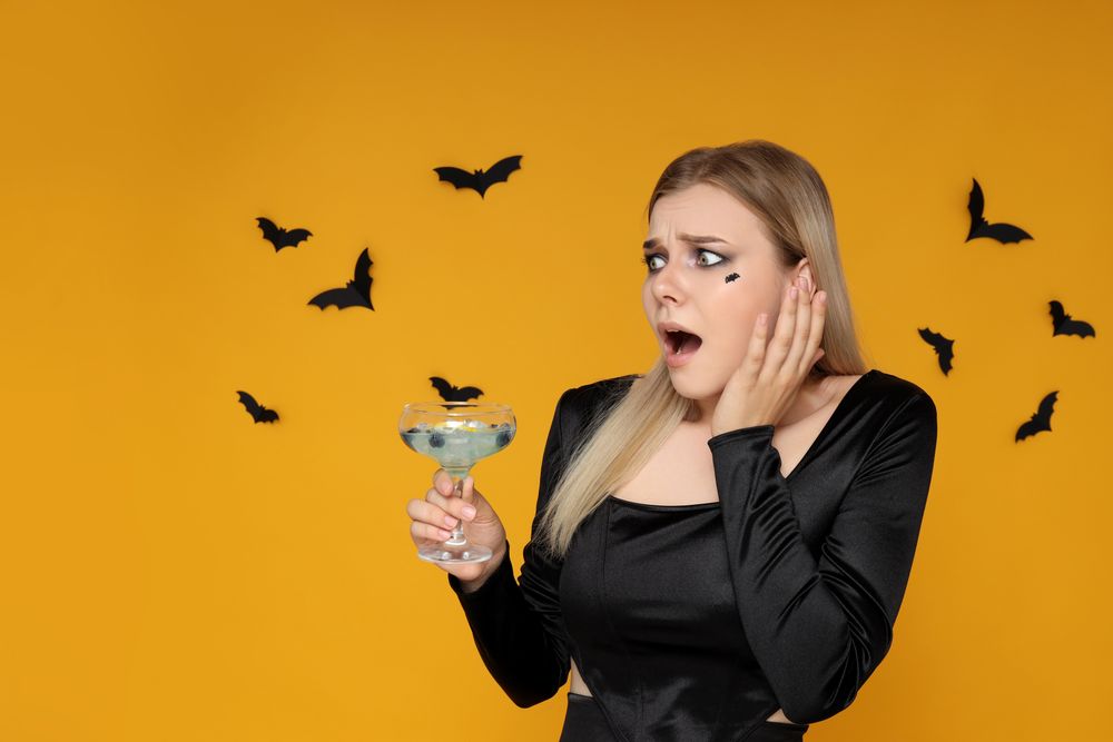 Concept of Halloween, young woman on yellow background