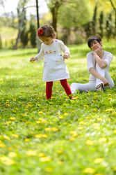 Mother watching her daughter walk in park