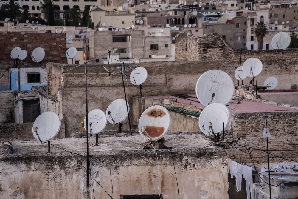 Many antennas on roofs on old buildings in city