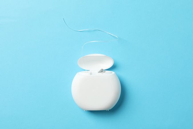 Dental floss on blue background, space for text