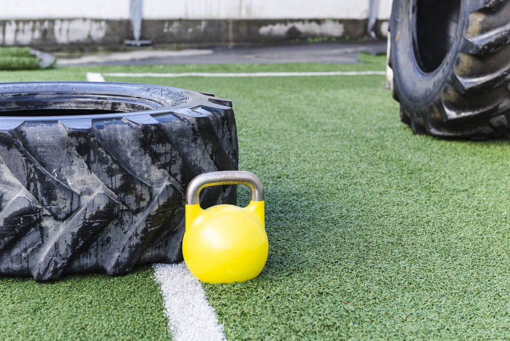 Heavy tires near kettlebell on lawn