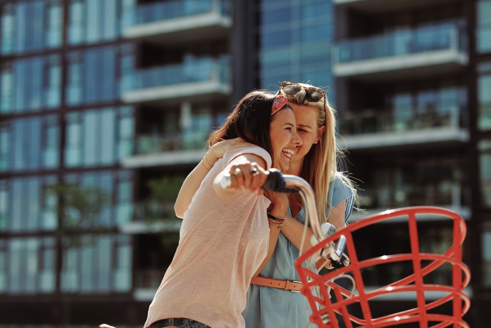 Two women standing and talking with bicycle