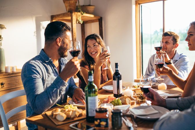 Men and women friends enjoying meal at home together