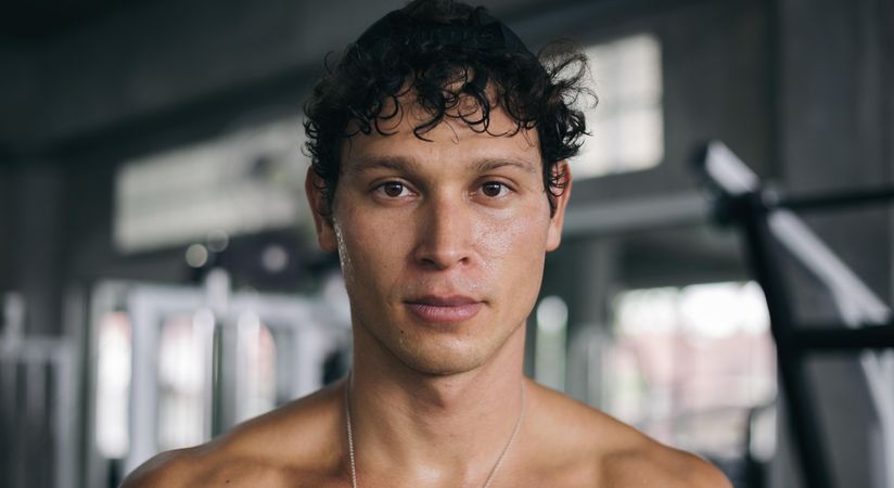 Dark haired male looking in camera in gym