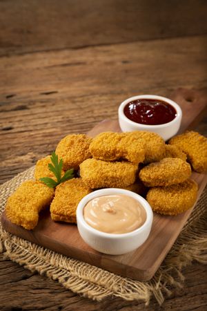 Fried chicken nuggets with ketchp and rose sauce.