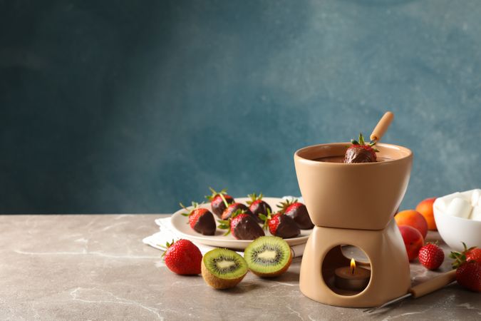 Composition with ingredients for chocolate fondue on gray table. Cooking fondue