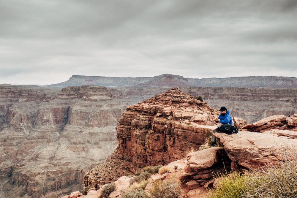 Male relaxing on cliff and admiring picturesque view