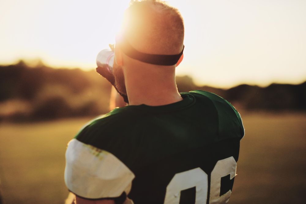 Man rehydrating during a football game