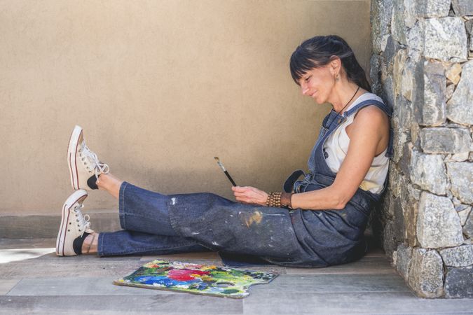 Portrait of a woman artist siting on the floor outdoors. Copy space