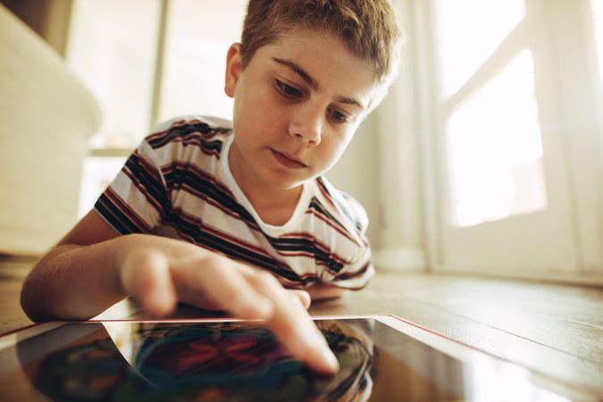 Close up of a boy playing games on a tablet pc