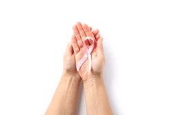 Female hands hold pink awareness ribbon, isolated on blank background