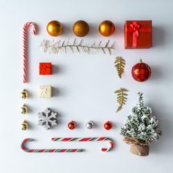 Christmas layout made of festive decorations, baubles, candy canes, presents on light background