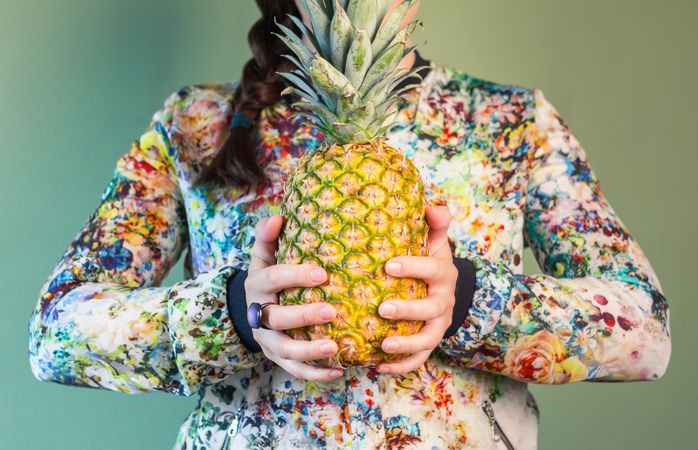 Woman holding pineapple between her hands