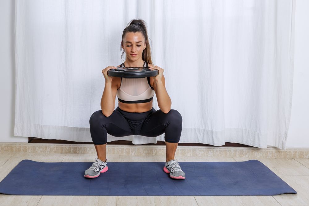 Young woman exercising using barbell