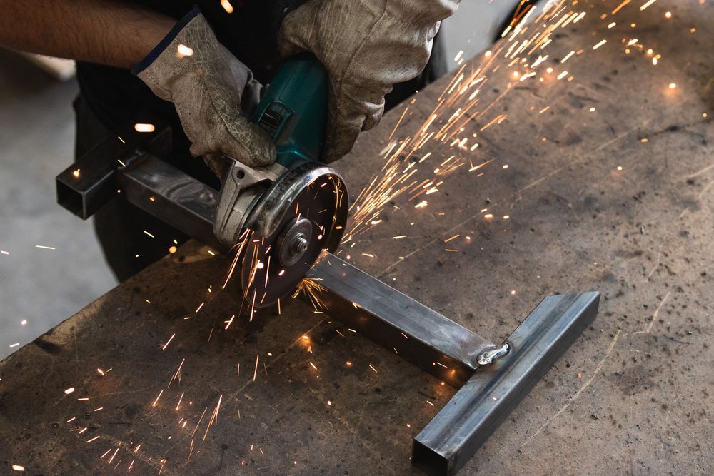 Male worker using electric grinder in workshop