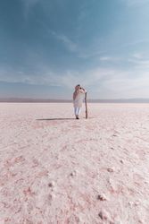 Thoughtful relaxed tourist enjoying unusual scenery of pink salt lake