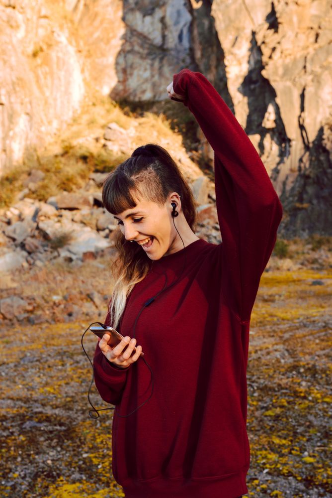 Young woman with smartphone dancing