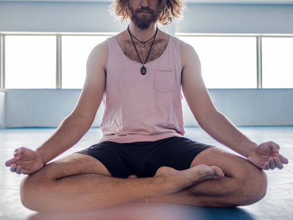 Male meditating in spacious room