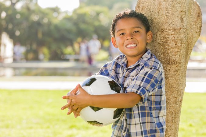 Happy Boy Holding Soccer Ball in the Park