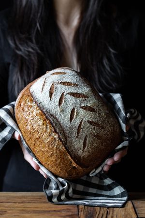 Crop person holding some bread