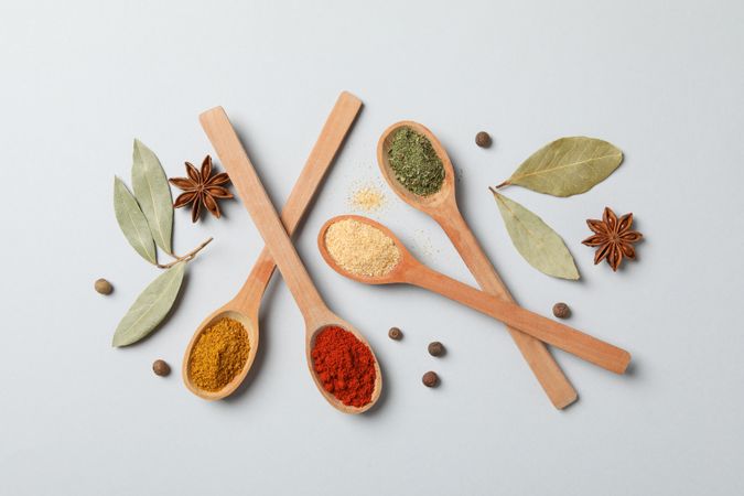 Top view of wooden spoons full of colorful earth tone spices