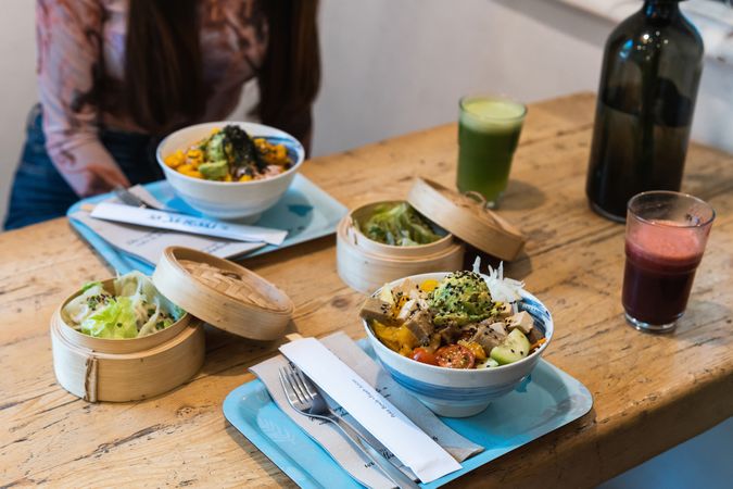 Crop woman eating poke dish in restaurant