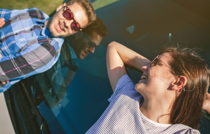 Young couple lying on the windshield