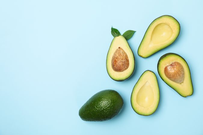Ripe fresh avocado on blue background, top view