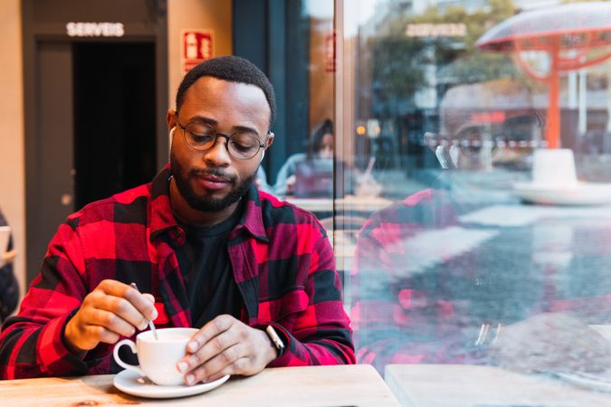 Black man with cup of coffee in cafe
