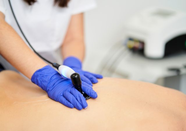 A female physiotherapist giving diathermy treatment on the patie