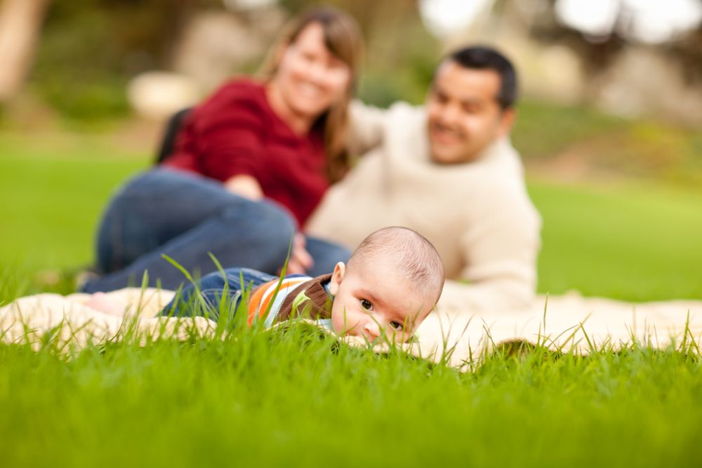 Happy Baby Boy and Parents Playing in the Park