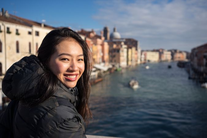 Asian female on vacation on ferryboat on waterline at city