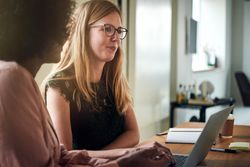 Two female colleagues reflecting during a meeting