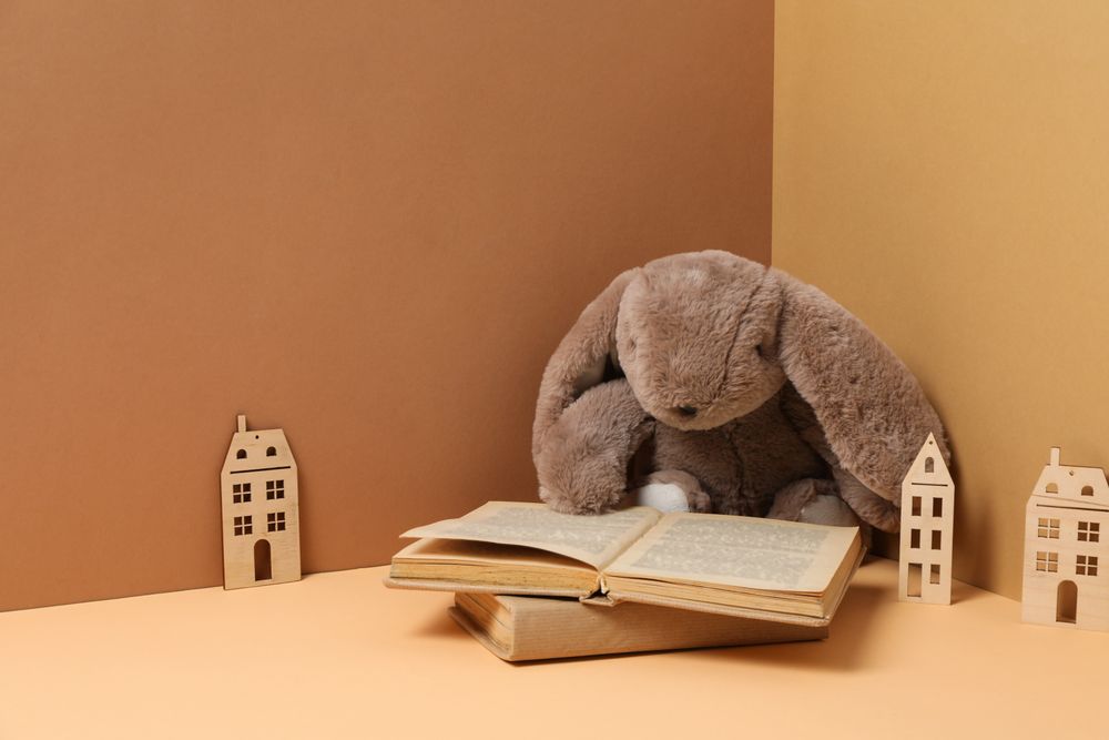 A children's book with toys on a beige background.