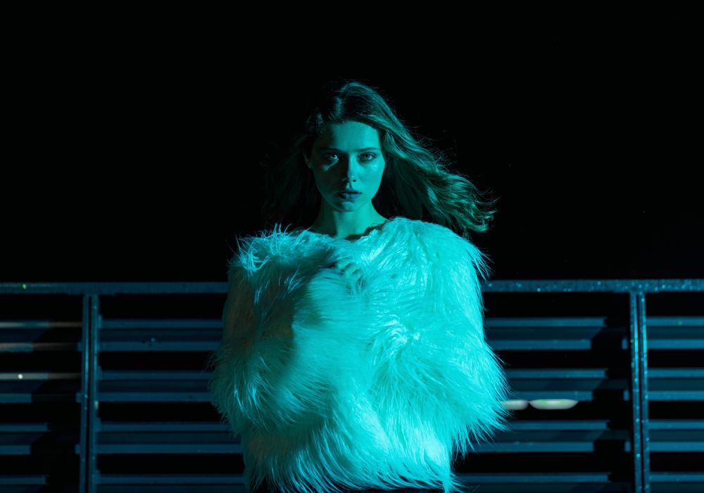 Woman at night wrapped in shaggy faux fur coat
