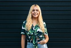 Portrait of a blonde woman outdoors against dark background