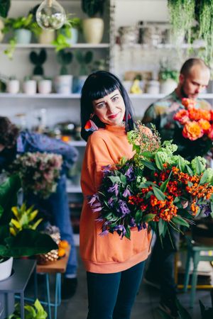 Woman carrying flowers in the flower shop.