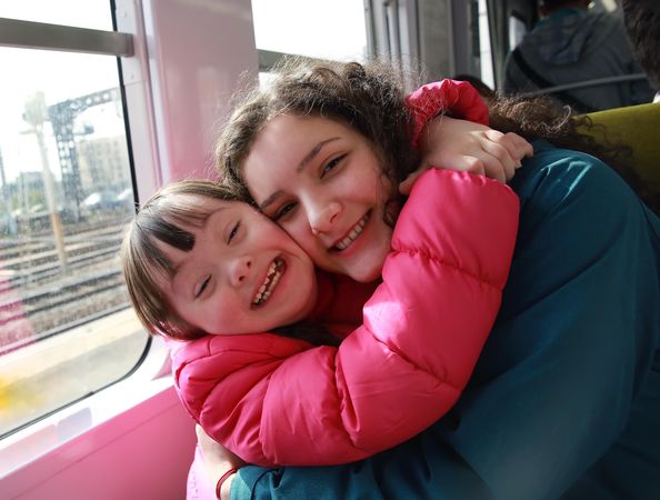 Two sisters embrace on the train
