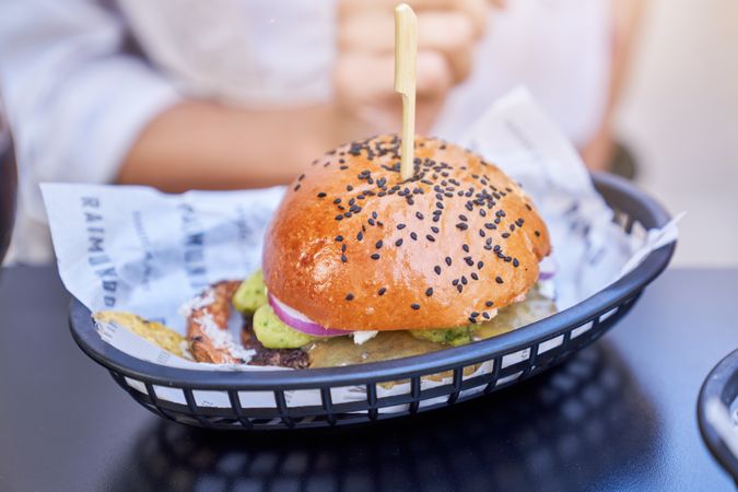Delicious burger in basket on table