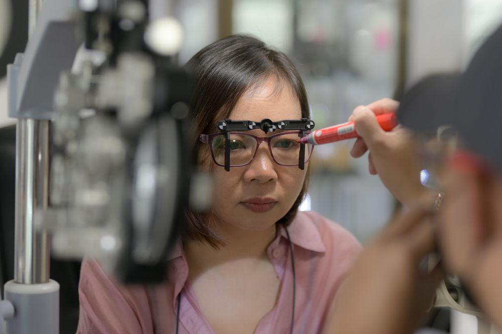 Young woman checking her eyesight and choosing glasses