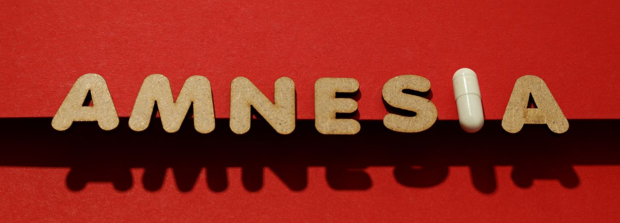 Cork letters of the word “Amnesia” with pill, wide shot