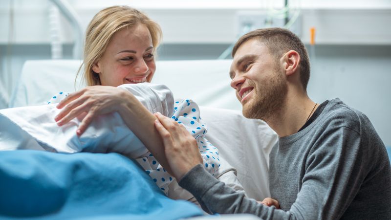 In the Hospital Mother Holds Newborn Baby, Supportive Father Lovingly Hugs Baby and Wife
