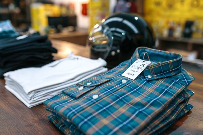 Close up of label with price and size over a blue plaid shirt on industrial style store