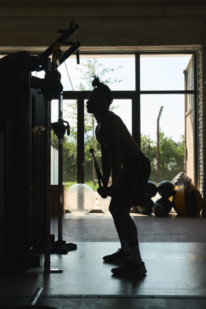 Black guy using exercise machine in gym