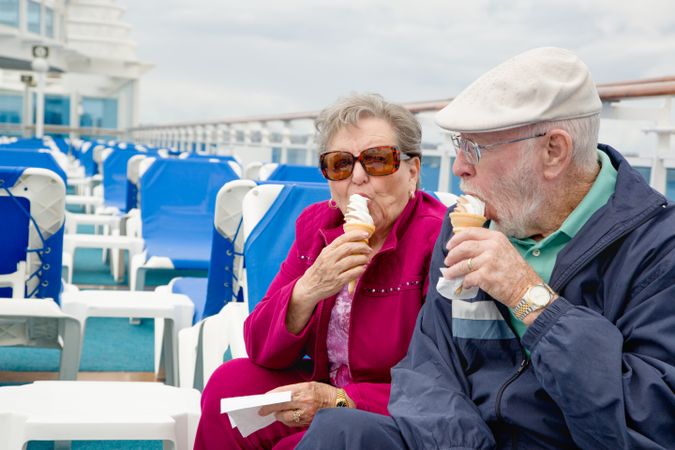 Happy Mature Adult Couple Enjoying Ice Cream On The Deck of a Luxury Passenger Cruise Ship.