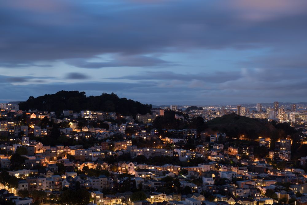 Cityscape on a green hill during evening