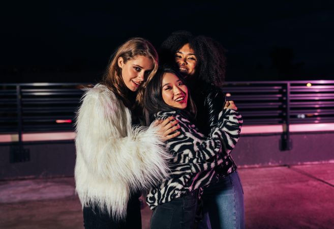 Multi-ethnic group of women in faux furs smiling in group portrait