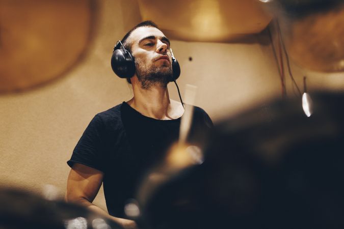Man with headphones playing on drums